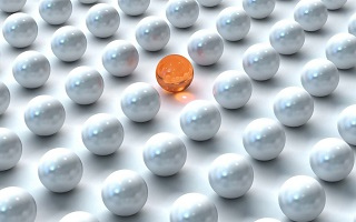 orange marble in group of white marbles