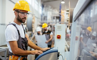 Worker wearing safety helmet operating a machine